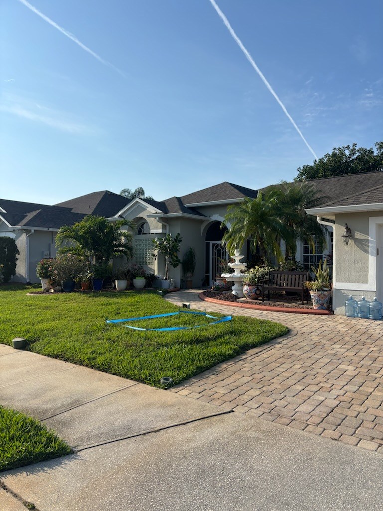 Cut lawn and cleaned-up beds along a paver driveway